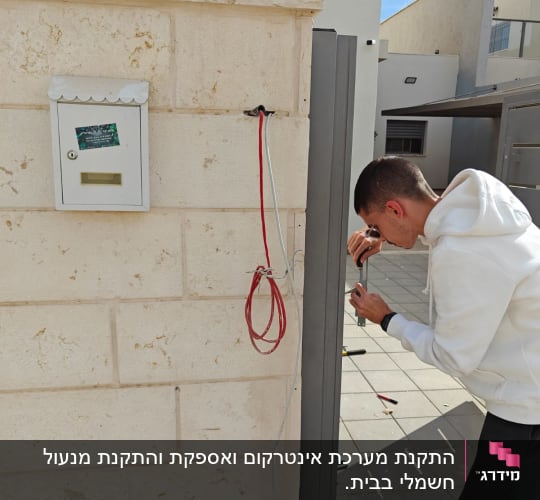 אדם מתקין אינטרקום עם חוטים חשמליים